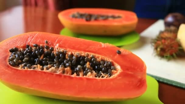 Exotische tropische vruchten op tafel. Thaise groenten. Papaya fruit in tweeën gesneden. Close-up — Stockvideo