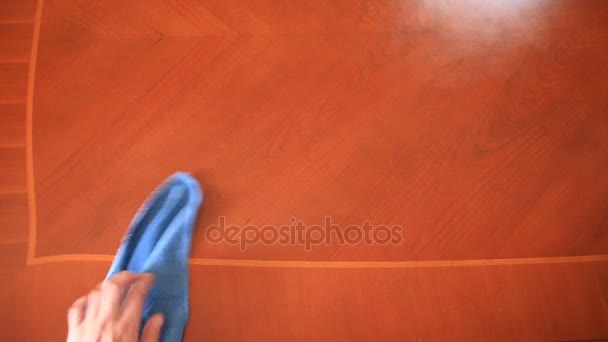 De hand houdt een blauwe doek en de stof van de tafel veegt — Stockvideo