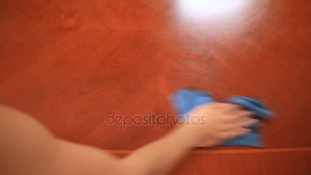 Ręka trzyma blue rag i ociera jego pyłu ze stołu — Wideo stockowe