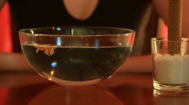 Bir mumla tahmin. Kadın balmumu içine su dökme. Soğutma balmumu suyla şeffaf bir kabın içinde yüzen