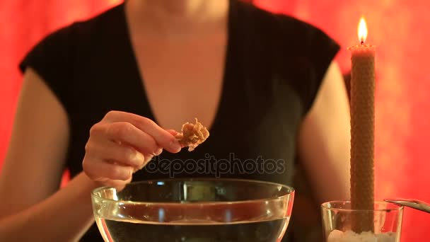 Immagino con una candela. Donna che versa la cera nell'acqua. Le mani femminili tolgono la cera raffreddata dall'acqua. Esaminare una figura di cera congelata — Video Stock