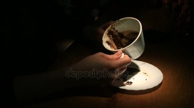 Kahve telvesi üzerinde bir kupa kahve telvesi ile tutan bir el tahmin. Yakın çekim.