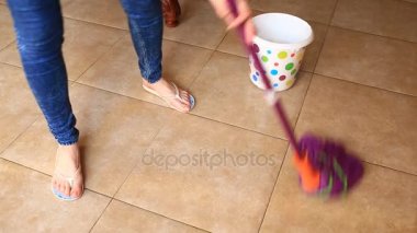 Bir kadın bir paspas ile mutfakta yere yıkar. Yukarıdan bir bez renkli bir kova daldırma, görüntüleme
