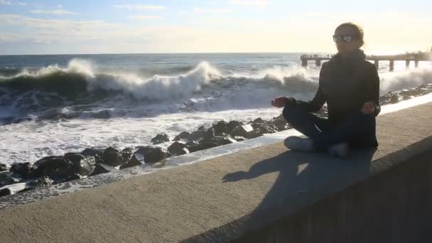 The woman is meditating on the beach during a storm. Equanimity, resistance to stress — Stock Video