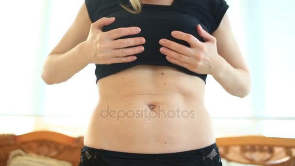 A woman is a fat stomach. Overweight and weight loss concept. A girl in a bathing suit pulls the skin on her stomach, which is stretched and flabby after losing weight or giving birth to a baby — Stock Video