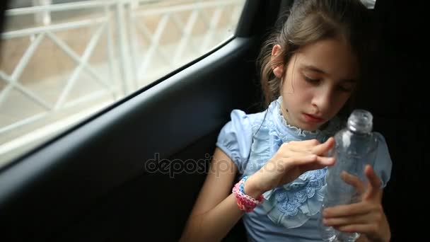 Arabada sıkılan küçük kız pencereden dışarı bakıyor. Sokak yansıması. — Stok video