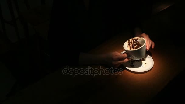 Devine sur le marc de café, une main de femme tenant une tasse de café. Gros plan .