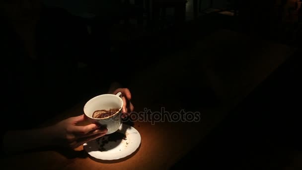 Adivinhar no café, uma mão feminina segurando uma caneca de café. Close-up . — Vídeo de Stock