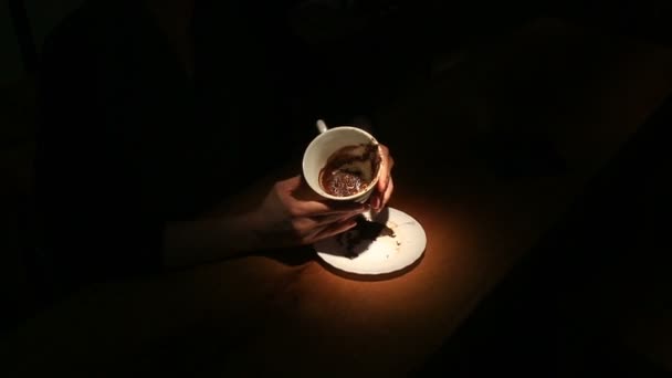 Gissen op de koffie gronden, een vrouwelijke hand met een koffiemok. Close-up. — Stockvideo