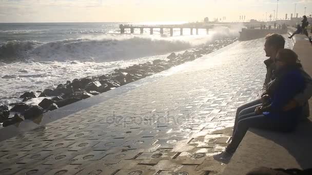 Une paire d'amoureux regardant une tempête assis. Ils sont assis embrassant sur le bord du remblai — Video