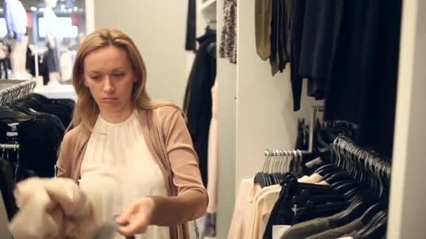 女人在衣服购物店，挑选衣服 — 图库视频影像