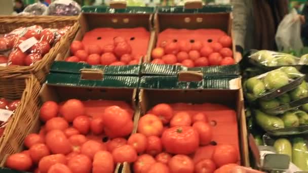 La gente en la tienda elige tomates para comprar — Vídeo de stock