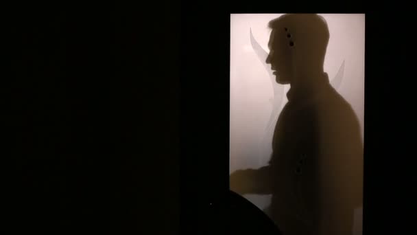 Silueta muže za skleněnými dveřmi. Mění svůj společenský oblek. — Stock video