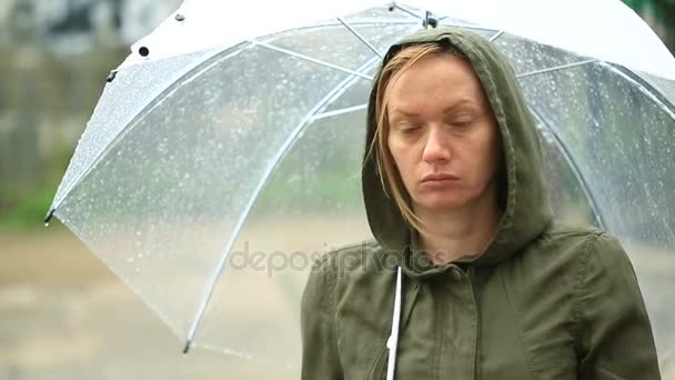 Sfrustrowany pogodą, stojący pod parasolem podczas deszczu. Nieszczęśliwa kobieta. — Wideo stockowe