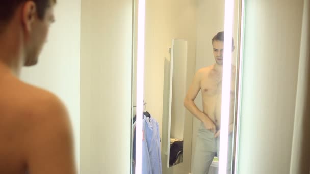Bir adam giyim kendisi için bir giyim mağazasında seçer. Montaj odasında yeni elbiseler üzerinde çalışıyor — Stok video