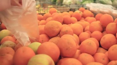 Yakın çekim, bir el, adamın portakal bir mağaza seçin