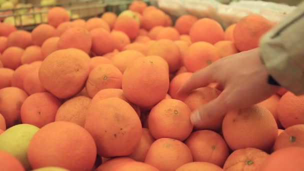 クローズ アップ、マンの手、店でオレンジを選択 — ストック動画