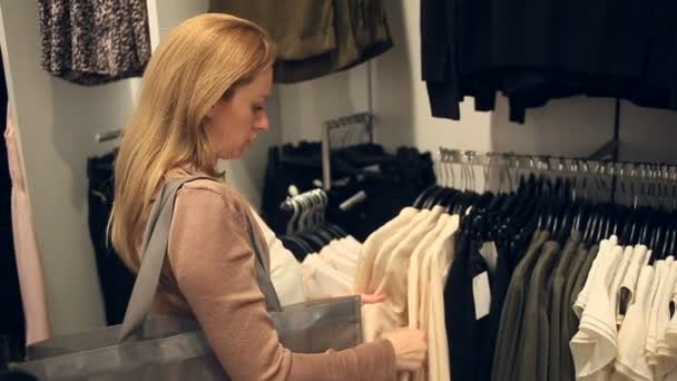 Mujer de compras en la tienda de ropa, elegir ropa — Vídeos de Stock