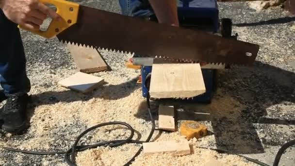 Un hombre aserrando madera Tablero con sierra manual. Primer plano. . — Vídeos de Stock