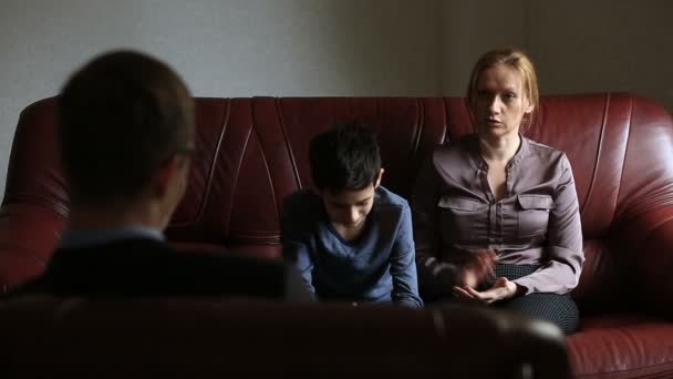 Консультация психолога. Мужской психолог консультирует женщину и ее сына-подростка, семейное консультирование — стоковое видео