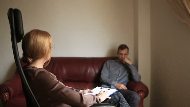 Consulta de un psicólogo, una terapeuta mujer está consultando a un paciente con un hombre con un trastorno de ansiedad, psicopatía . — Vídeo de stock