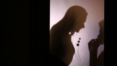 Bir kadın ve bir çocuk bir cam kapının arkasında arasında bir kavga silüeti. Oğlu anne kızıyor