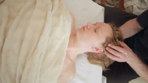 顔と頭のマッサージを女性に行って男性マッサージセラピスト. — ストック動画