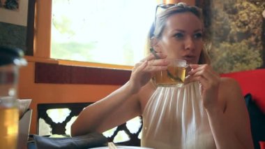 Kadın bir çaydanlık şeffaf yeşil çay içiyor. Arkadaşlar Çin yemeği bir Çin restoranında yemek.