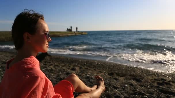 Retrato de una hermosa mujer en el primer plano de la playa. ver chica con gafas de sol sonriendo — Vídeos de Stock