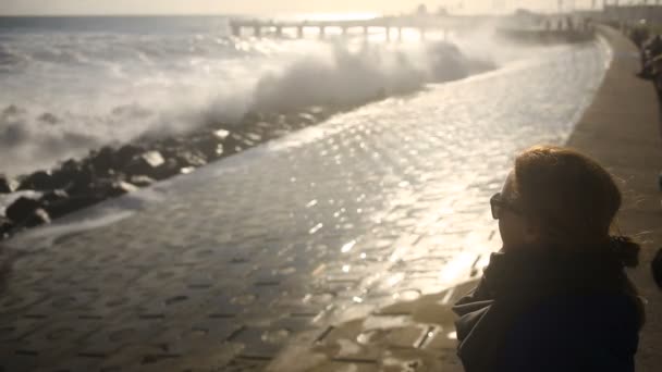 Meisje in een storm zitten kijken zonnebril. — Stockvideo