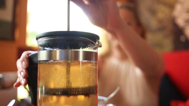 La donna beve il tè verde da una teiera trasparente. Gli amici mangiano cibo cinese in un ristorante cinese — Video Stock