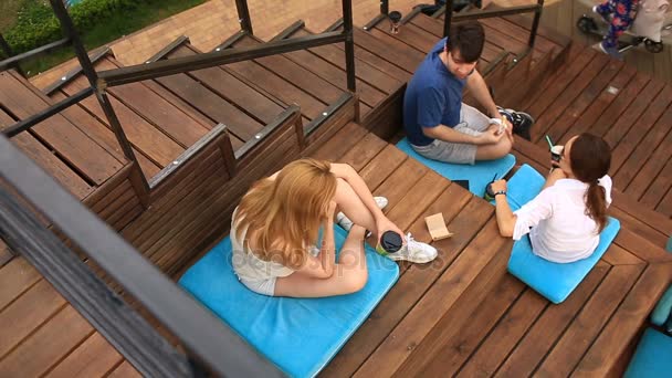 Venner drikker kaffe og chatter i en uformel udendørs cafe. Fast food – Stock-video