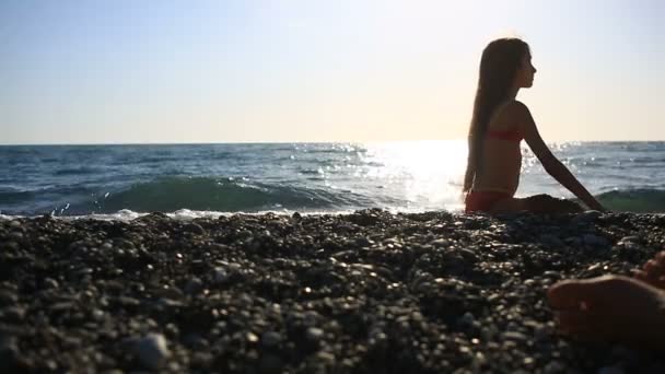 I bambini con la madre riposano sulla spiaggia mentre la mamma prende il sole — Video Stock