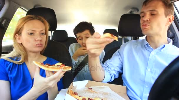 Familie, mama, papa und sohn essen pizza im auto — Stockvideo