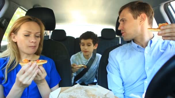 Family, mom, dad and son eating pizza in the car — Stock Video