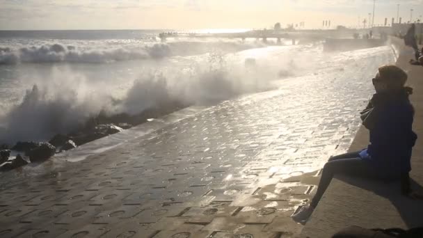 Девушка в солнечных очках смотрит на сидящий шторм . — стоковое видео