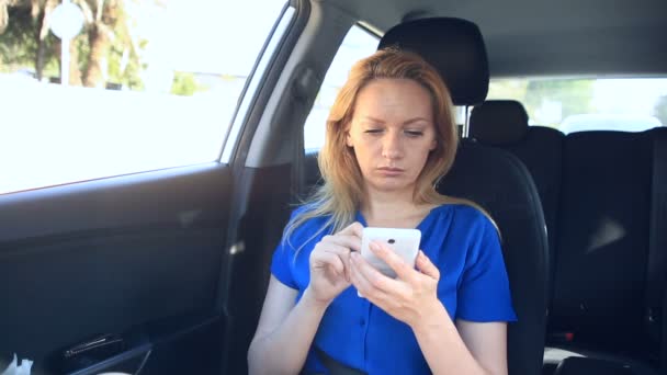 Een meisje is het rijden in de auto naast de chauffeur en is praten over de telefoon — Stockvideo