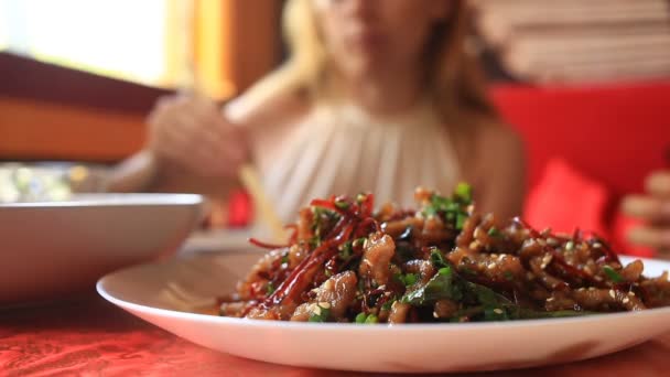 Gli amici mangiano cibo cinese in un ristorante cinese . — Video Stock