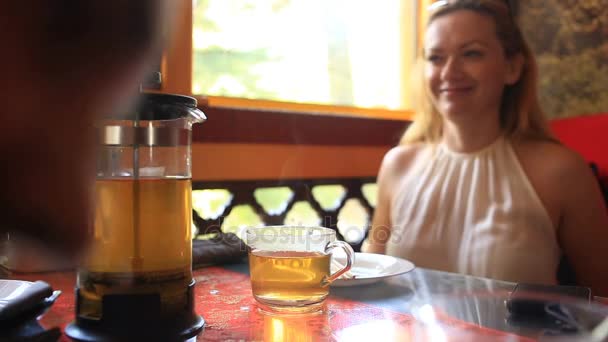 Femme boit du thé vert dans une théière transparente. Des amis mangent chinois dans un restaurant chinois — Video