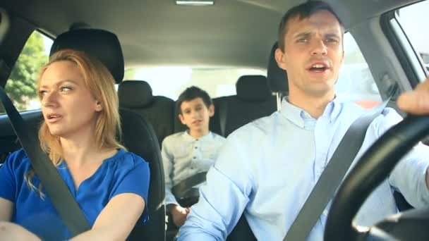 Семья, мама, папа и сын едут в машине, поют песни со всей семьей — стоковое видео