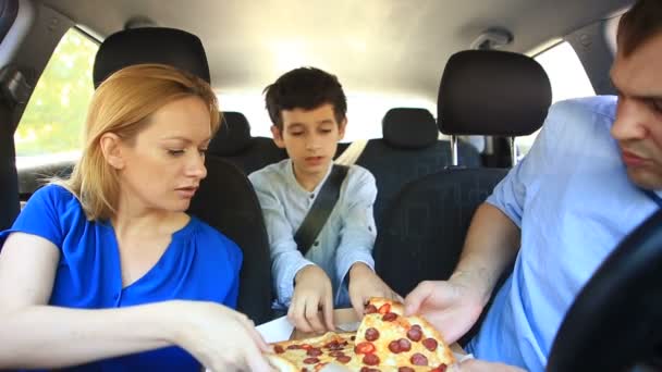 Семья, мама, папа и сын едят пиццу в машине — стоковое видео