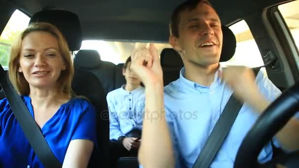 Семья, мама, папа и сын едут в машине, поют песни со всей семьей — стоковое видео