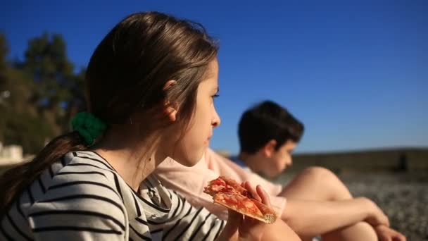 Enfants avec mère mangeant de la pizza sur la plage — Video