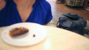 Bir kadın bir kafede onun cüzdan kurnaz bir yankesici tarafından çalındı şüpheli değil. Bir pasta ile kahve içiyor, hırsız bir çanta cüzdan çaldı