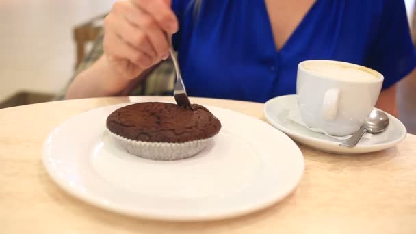 Kvinna i ett café som dricker kaffe med choklad tårta — Stockvideo
