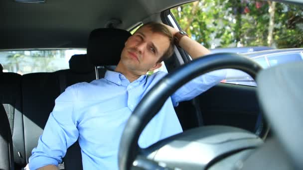 Водитель мужчины заснул на водительском сидении на обочине оживленной дороги. Ожидание в машине — стоковое видео