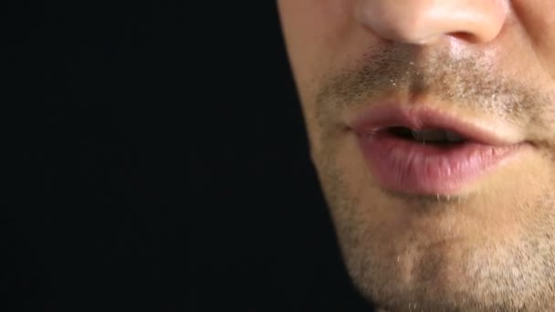 Uma pessoa sussurra para a câmara. Close-up dos lábios. sussurro Em um fundo preto — Vídeo de Stock