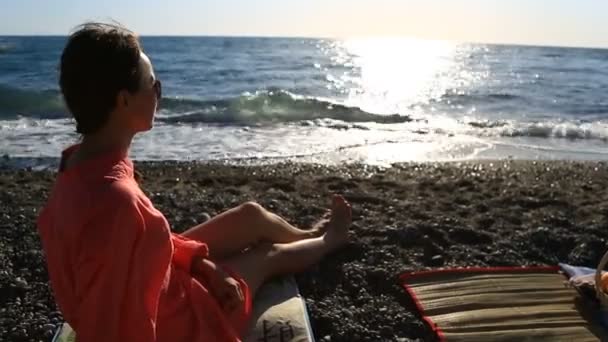 Retrato de una hermosa mujer en el primer plano de la playa. ver chica con gafas de sol sonriendo — Vídeos de Stock