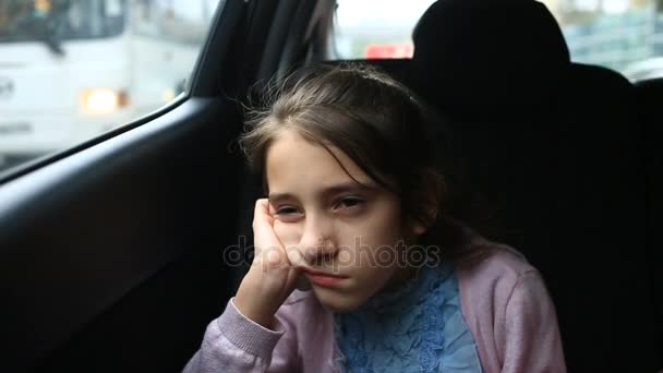 小さな女の子は、車の中で退屈-窓から窓の外を見る-通りの反射 — ストック動画