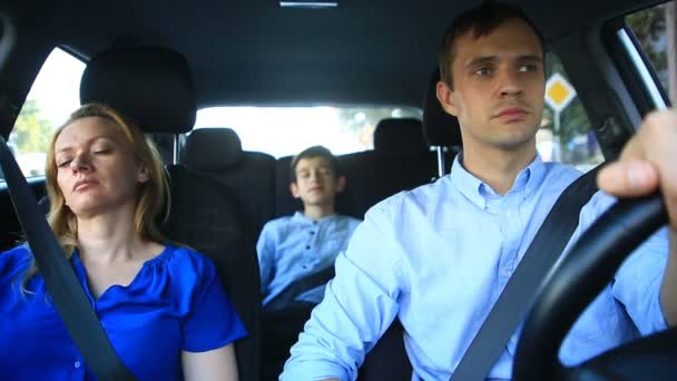 Сім'я, мама, тато і син йдуть в машину, мати і дитина сплять під час подорожі в машині — стокове відео
